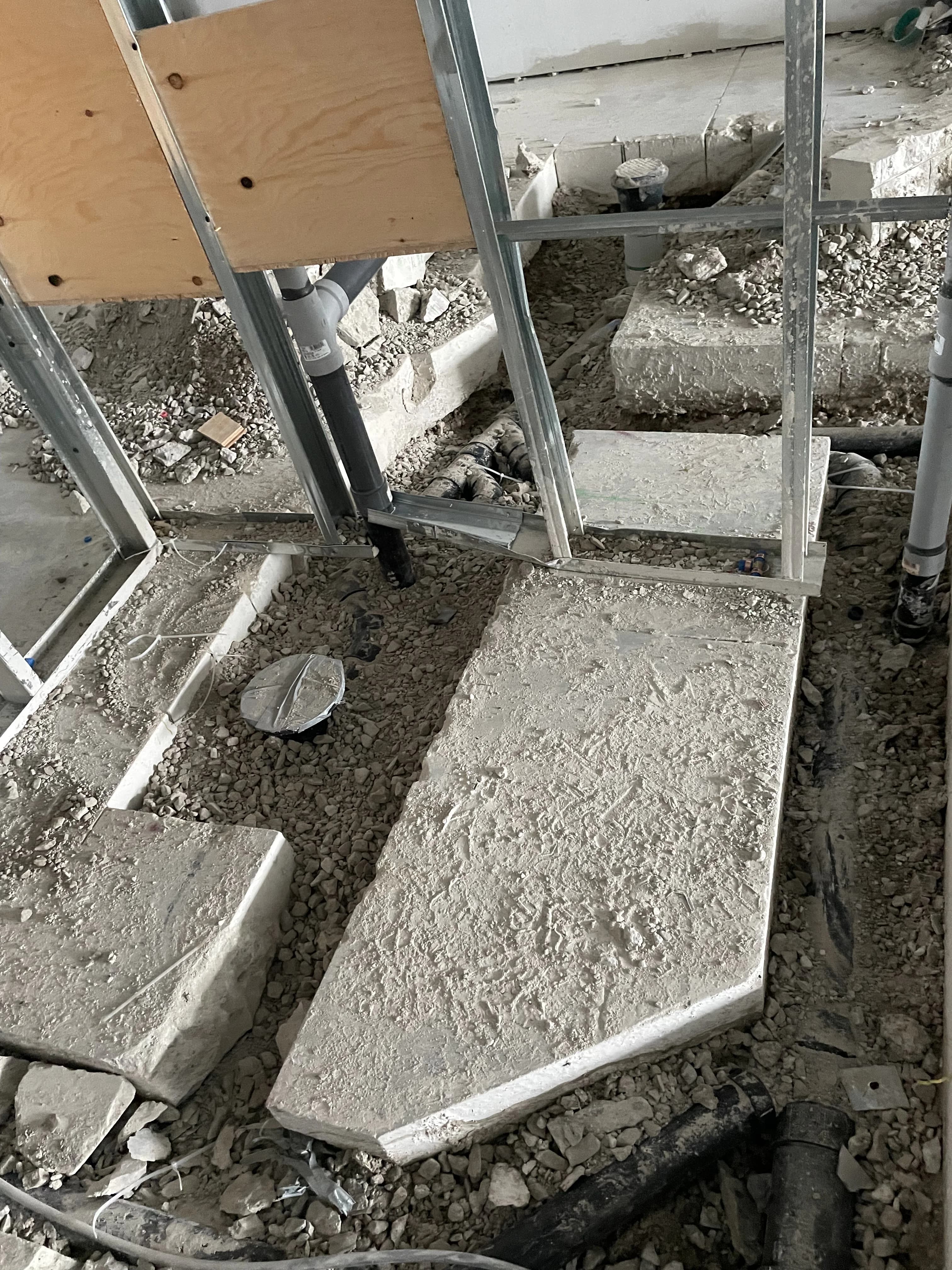 Commercial floor drains and metal stud framing during plumbing rough-in in Ajax