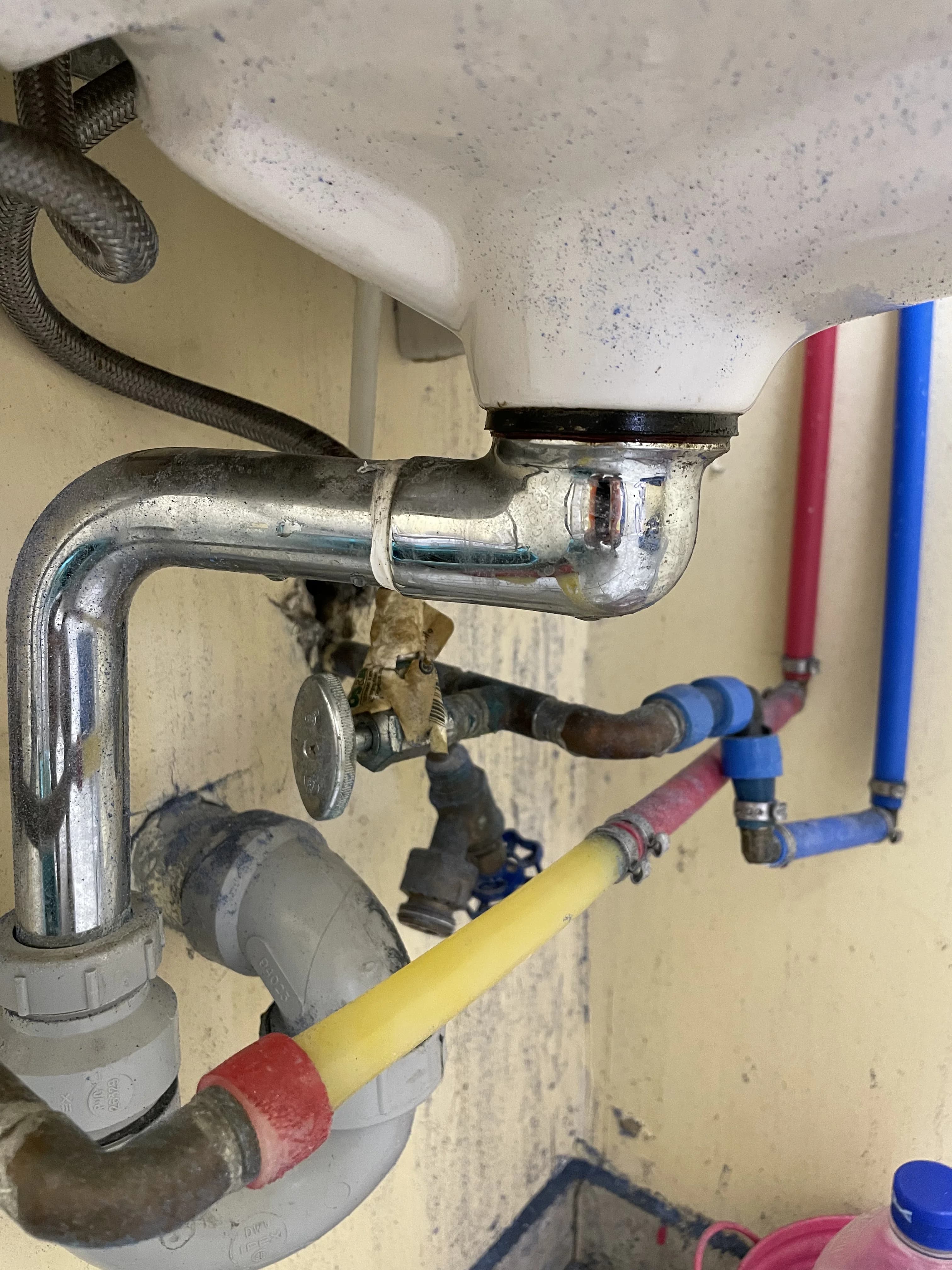 Emergency plumbing repair in Ajax under a kitchen sink with PEX supply lines and a chrome P-trap