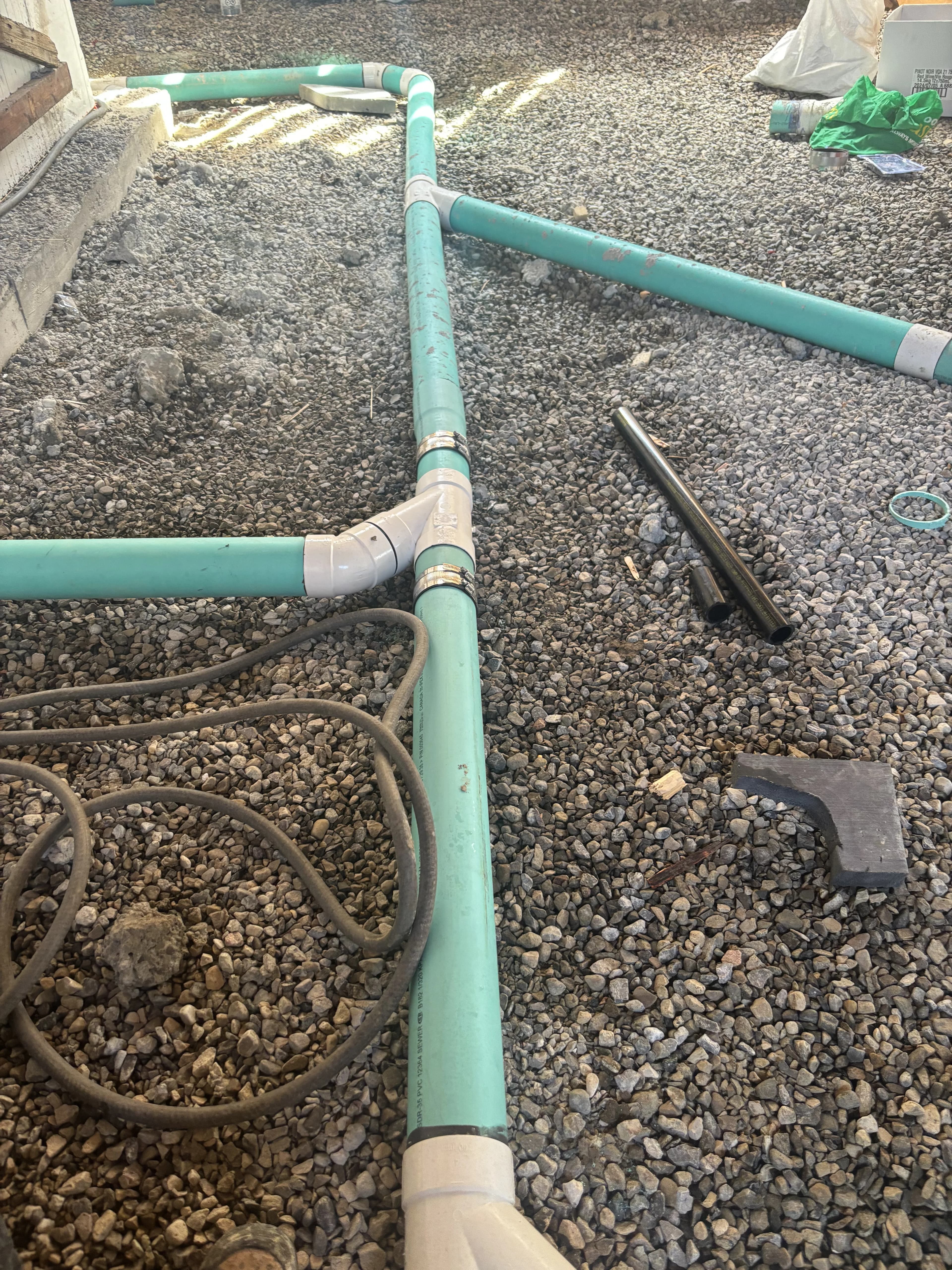 Sewer line installation in Ajax with green PVC on a gravel bed and shielded couplers